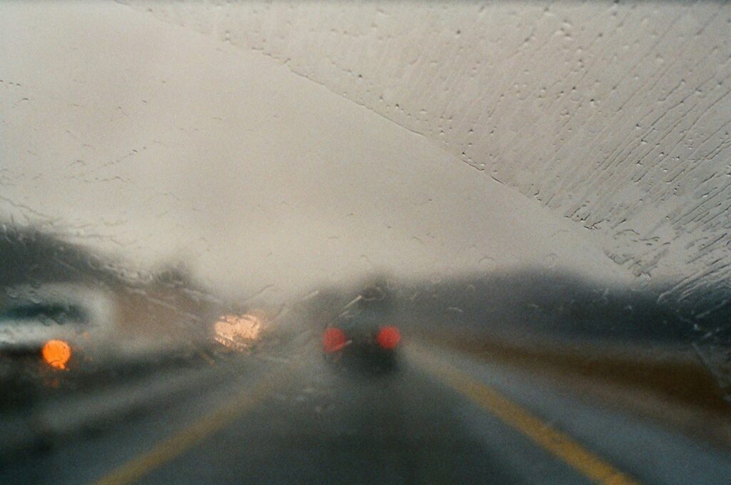 The view from a wet car windshield looking into traffic