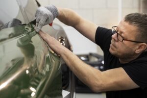 a person working on car windshield