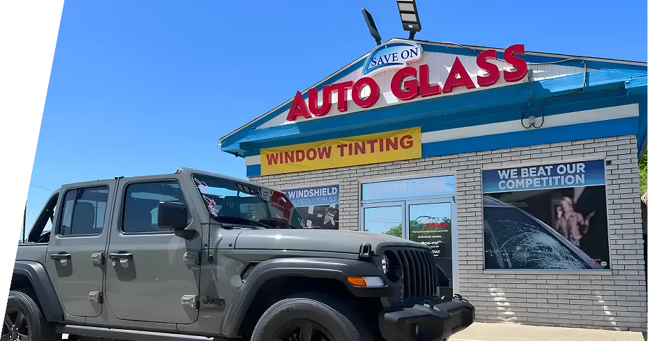 Gray Jeep Wrangler parked outside Save On Auto Glass on a sunny day.