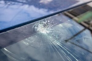 Broken windshield with a lot of cracks and small glass pieces