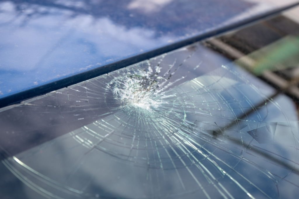 Broken windshield with a lot of cracks and small glass pieces