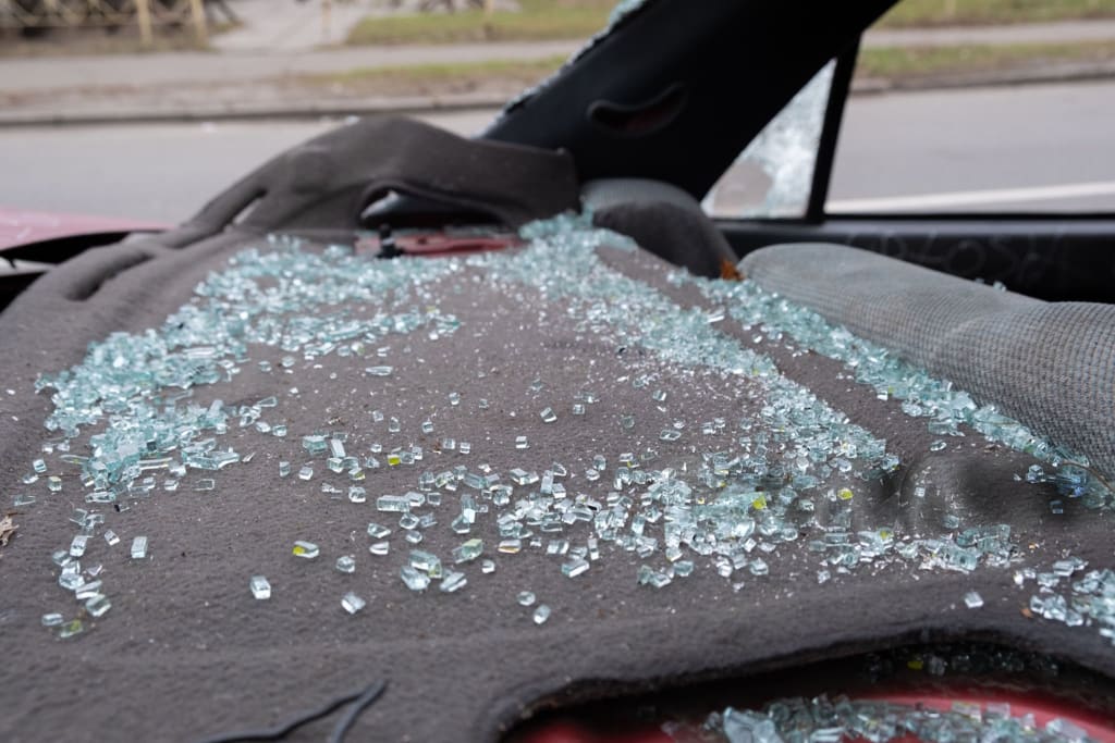 The interior of the vehicle is covered in shattered glass following a sudden and unfortunate accident incident