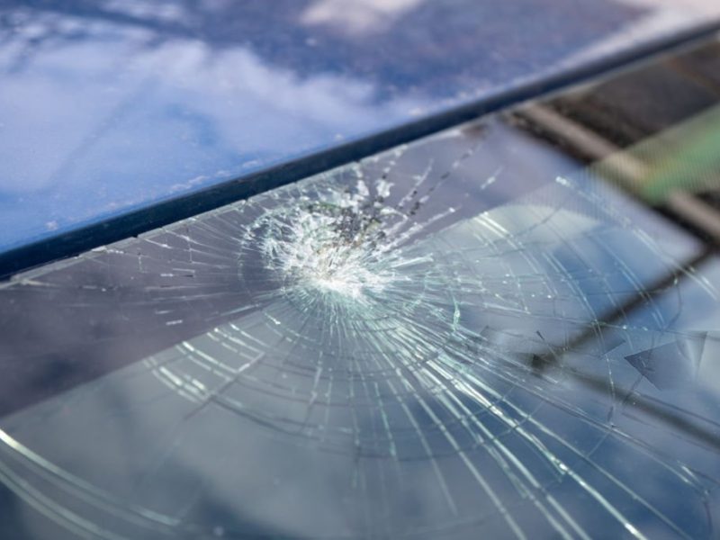 Broken windshield with a lot of cracks and small glass pieces
