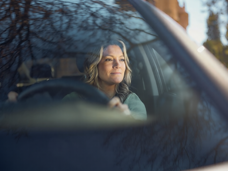Smiling woman enjoying while driving a car