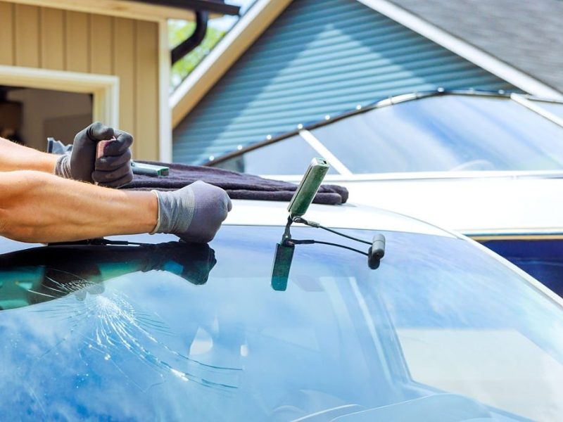 Windshield repair process taking place in residential area during works day