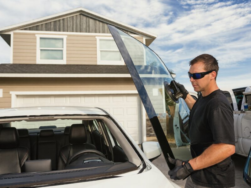 a  man replacing Car WIndshield