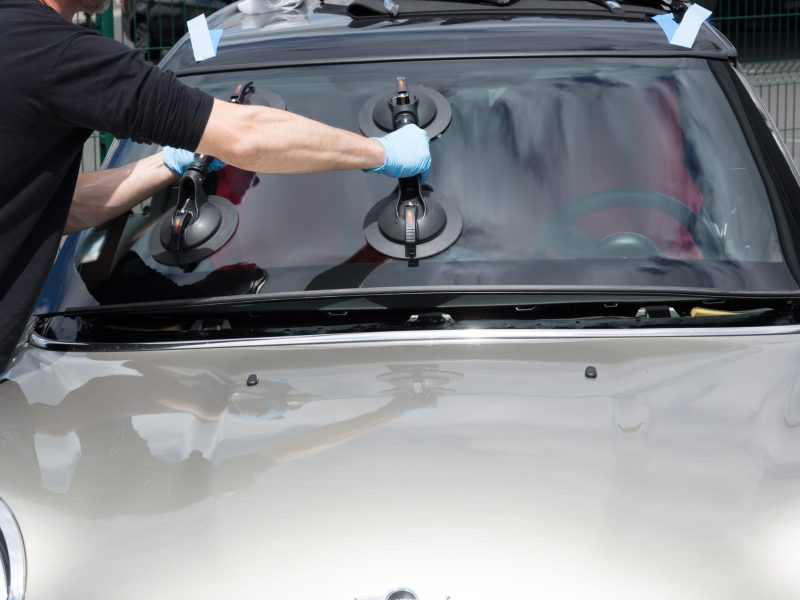 A person is installing a new windshield